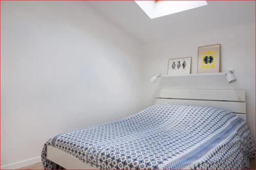 - une chambre blanche avec un lit et une couverture bleue dans l'établissement Charmante maison Les Glycines DisneyLand Paris, à Montry