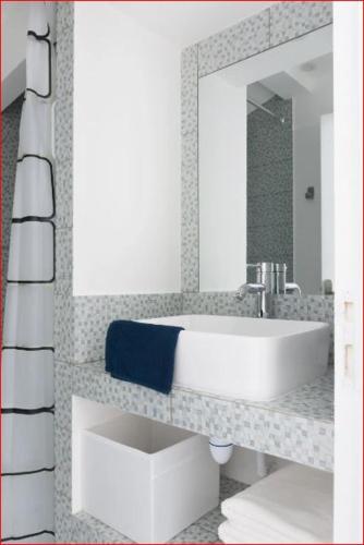 une salle de bain avec un lavabo blanc et un miroir dans l'établissement Charmante maison Les Glycines DisneyLand Paris, à Montry