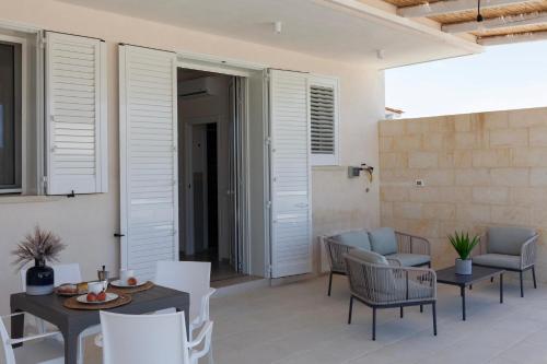 a living room with white chairs and a table at Villa La Reimunda in Otranto