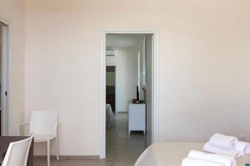 a bedroom with white walls and a table and chairs at Villa La Reimunda in Otranto