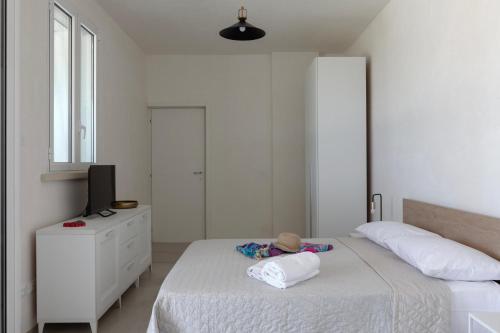 a white bedroom with a bed and a television at Villa La Reimunda in Otranto