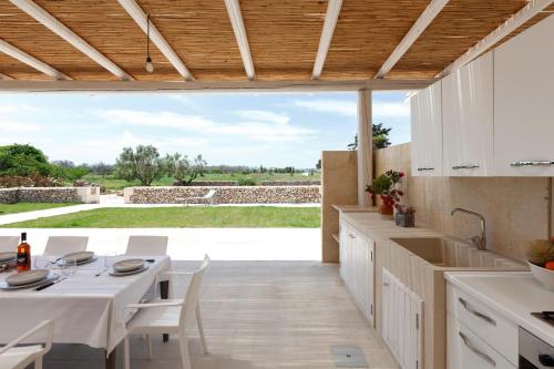 a kitchen with a table and a view of a field at Villa La Reimunda in Otranto