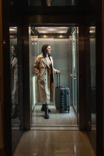 a woman walking through a door with a suitcase at Paria Hotel in Kudowa-Zdrój
