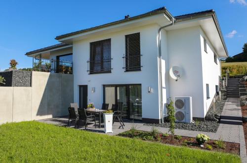 a white house with a table and chairs at Rüters Parkhotel in Willingen