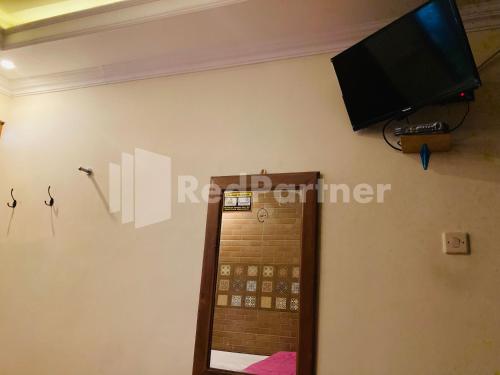 a flat screen tv on the wall of a bathroom at Sahil inn Syariah Prawirotaman RedPartner in Timuran