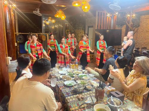 a group of people standing around a table with food at Pù Luông Sala Homestay in Hương Bá Thước
