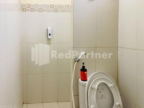 a bathroom with a toilet with a red extinguisher at Sahil inn Syariah Prawirotaman RedPartner in Timuran