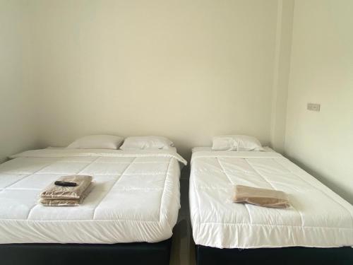 two beds sitting next to each other in a room at Dino Homestay in Ban Muang Chum