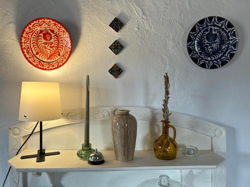 a table with a lamp and plates on the wall at Las casillas de la Villa ALEGRÍAS in Montefrío