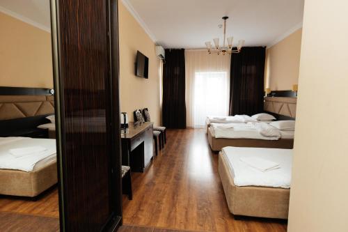 a hotel room with two beds and a mirror at ALCAZAR in Atyraū