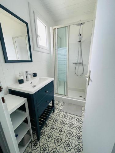 une salle de bain avec un lavabo et une douche dans l'établissement L'Echo des Vagues, à Vieux-Boucau-les-Bains