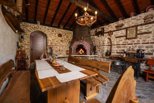 a dining room with a table and a fireplace at Villa Komitata-Pool and Jacuzzi in Balchik