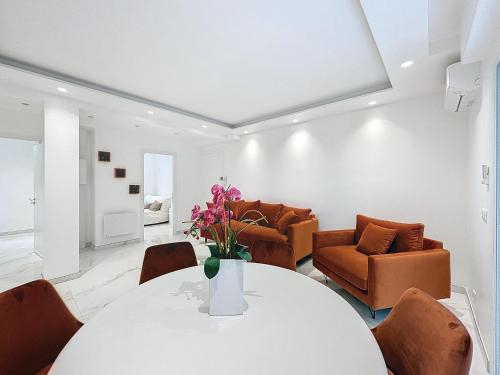 un salon avec une table et des chaises blanches dans l'établissement Résidence Lacour, à Cannes