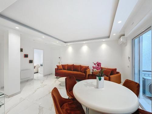 un salon avec une table et des chaises blanches dans l'établissement Résidence Lacour, à Cannes