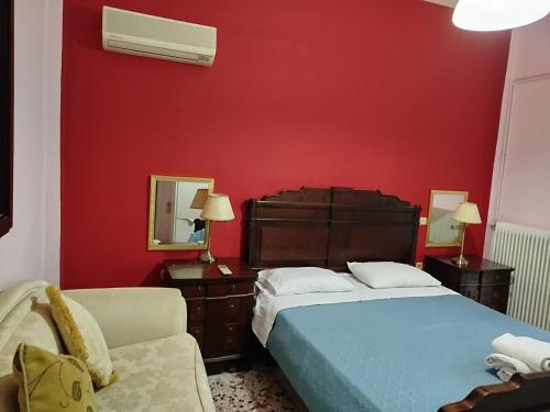 a red bedroom with a bed and a chair at Barbara's Sea View Home in Benitses