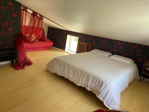 - une chambre avec un lit blanc et un canapé rouge dans l'établissement Charentaise contemporaine, à Anais
