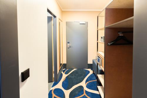a room with a closet with a bed and a door at Holiday Inn - the niu, Stream Mönchengladbach by IHG in Mönchengladbach