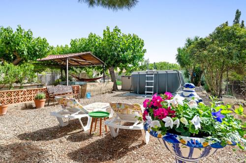 a patio with a table and chairs and flowers at Can Wancho in Botarell
