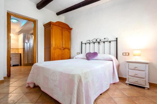 a bedroom with a bed with a white blanket at Can Wancho in Botarell