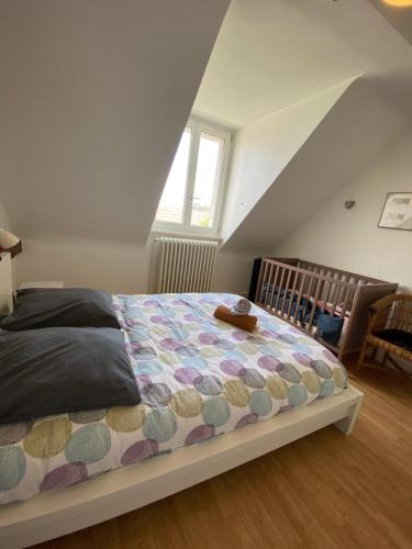 une chambre avec un lit dans un grenier dans l'établissement BookingAlsace - Maison Mittelharth Parking Jardin, à Colmar