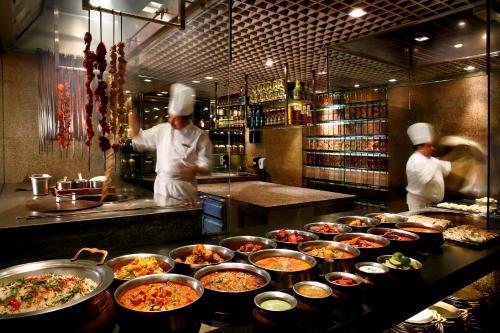 two chefs preparing food in a restaurant kitchen at Grand Hyatt Singapore in Singapore