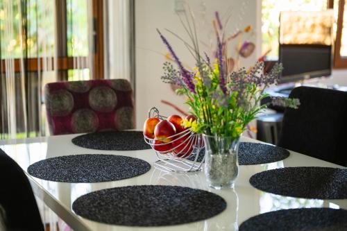 a table with a bowl of fruit and a vase of flowers at Villa Komitata-Pool and Jacuzzi in Balchik