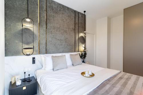 a bedroom with a white bed with a tray on it at Sol Marina Resort Wyspa Sobieszewska II - LoftAffair Collection in Wiślinka