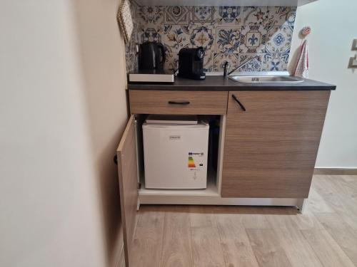 a kitchen counter with a sink and a refrigerator at Namastè Apartments Agrigento in Agrigento
