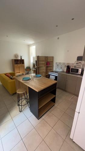 une cuisine avec une table et un canapé jaune dans l'établissement Appartement cosy, à Hyères