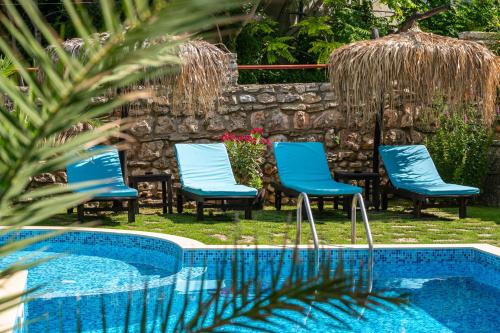 a group of blue chairs next to a swimming pool at Villa Komitata-Pool and Jacuzzi in Balchik