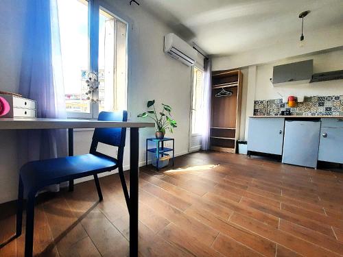 - une cuisine avec une table et une chaise bleue dans la chambre dans l'établissement La chambre 2, Climatisée AC, Calme, Cuisine privée, à Nice