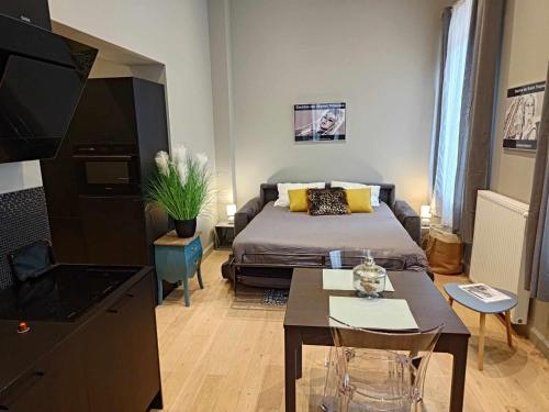 Cette petite chambre comprend un lit et une table. dans l'établissement le bardo, à Aix-les-Bains