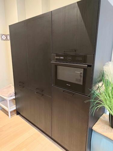 une armoire noire avec un micro-ondes et un four dans l'établissement le bardo, à Aix-les-Bains