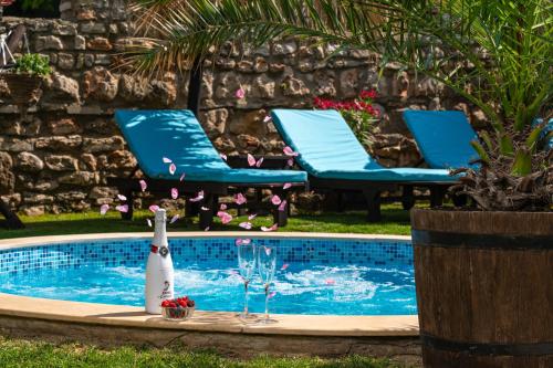 a swimming pool with two chairs and a bottle of champagne at Villa Komitata-Pool and Jacuzzi in Balchik