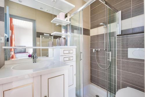 une salle de bain avec un lavabo et une douche en verre dans l'établissement Maison avec terrasse pour 5 - Calme et plage, à Longeville-sur-Mer