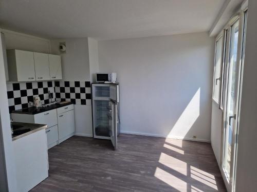 une cuisine avec des armoires blanches et un four à plaques de cuisson dans l'établissement Location Studio meublé période Jeux Olympiques, à Rosny-sous-Bois