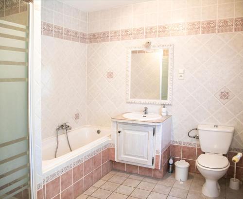 a bathroom with a tub and a toilet and a sink at Domaine Saint Ferreol in Nizas