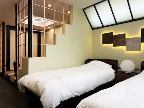 a bedroom with two beds and a large window at Rong Hua Grand Hotel ロンカグランドホテル in Isahaya