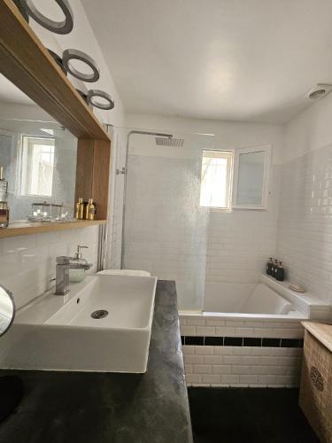 La salle de bains blanche est pourvue d'un lavabo et d'une baignoire. dans l'établissement Villa piscine prive & jacuzzi 300 de la mer, à Saint-Cyr-sur-Mer