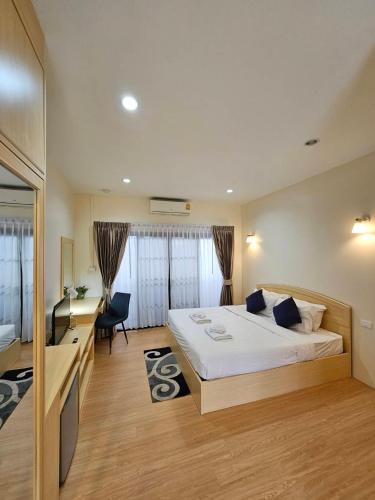a bedroom with a large bed with a desk and a desk at Mercy Hostel in Chiang Rai