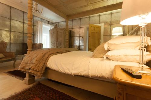 a bedroom with a bed and a table with a lamp at Meifod House in Caernarfon