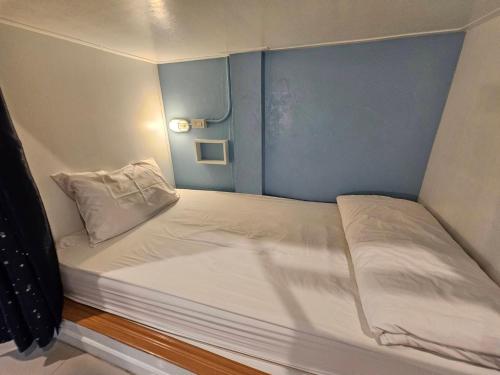 a small bed in a small room at Mercy Hostel in Chiang Rai