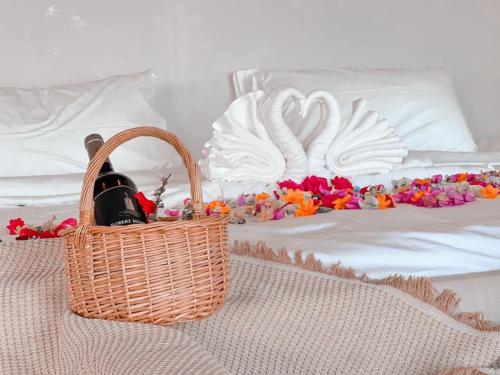 a basket of wine and flowers on a bed at Pool villa Doi Chang in Ban Huai Khai
