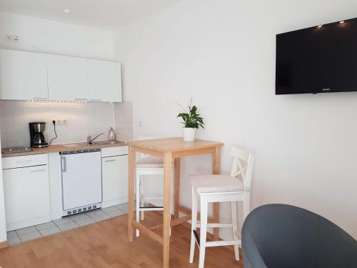 una cucina con tavolo, sedie e televisione di Studio Dresden Neustadt & parking a Dresda