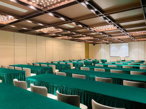 an empty room with green tables and chairs at DongHu Resort Hotel in Sihanoukville