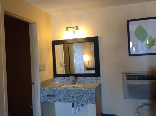 un baño con lavabo y espejo en DIAMOND INN & SUITES, en Richmond