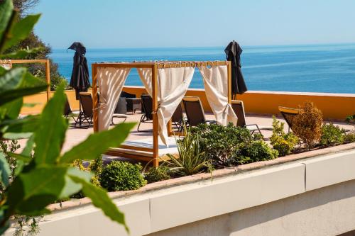 a patio with a table and chairs and the ocean at Hôtel La Pérouse Nice Baie des Anges in Nice