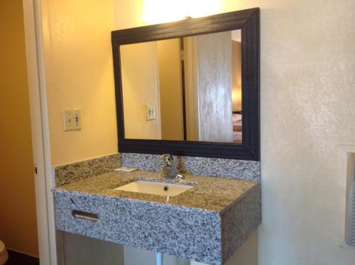 a bathroom with a sink and a mirror at DIAMOND INN & SUITES in Richmond