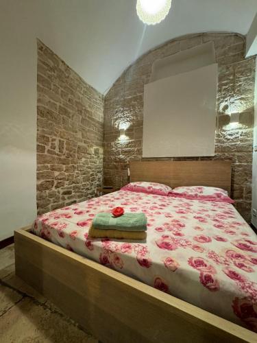 a bedroom with a large bed with roses on it at La Cattedrale in Bisceglie