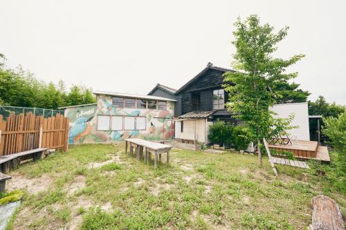 a house with a mural on the side of it at 古民家リトルヴィラTokorangi 自然派オーガニックヴィラ 画像内の滞在時のお願いを必ずご確認お願いします in Tokoname